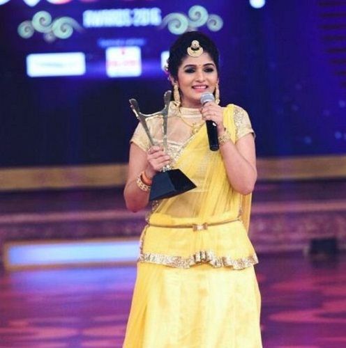 Divya Suresh holding her award