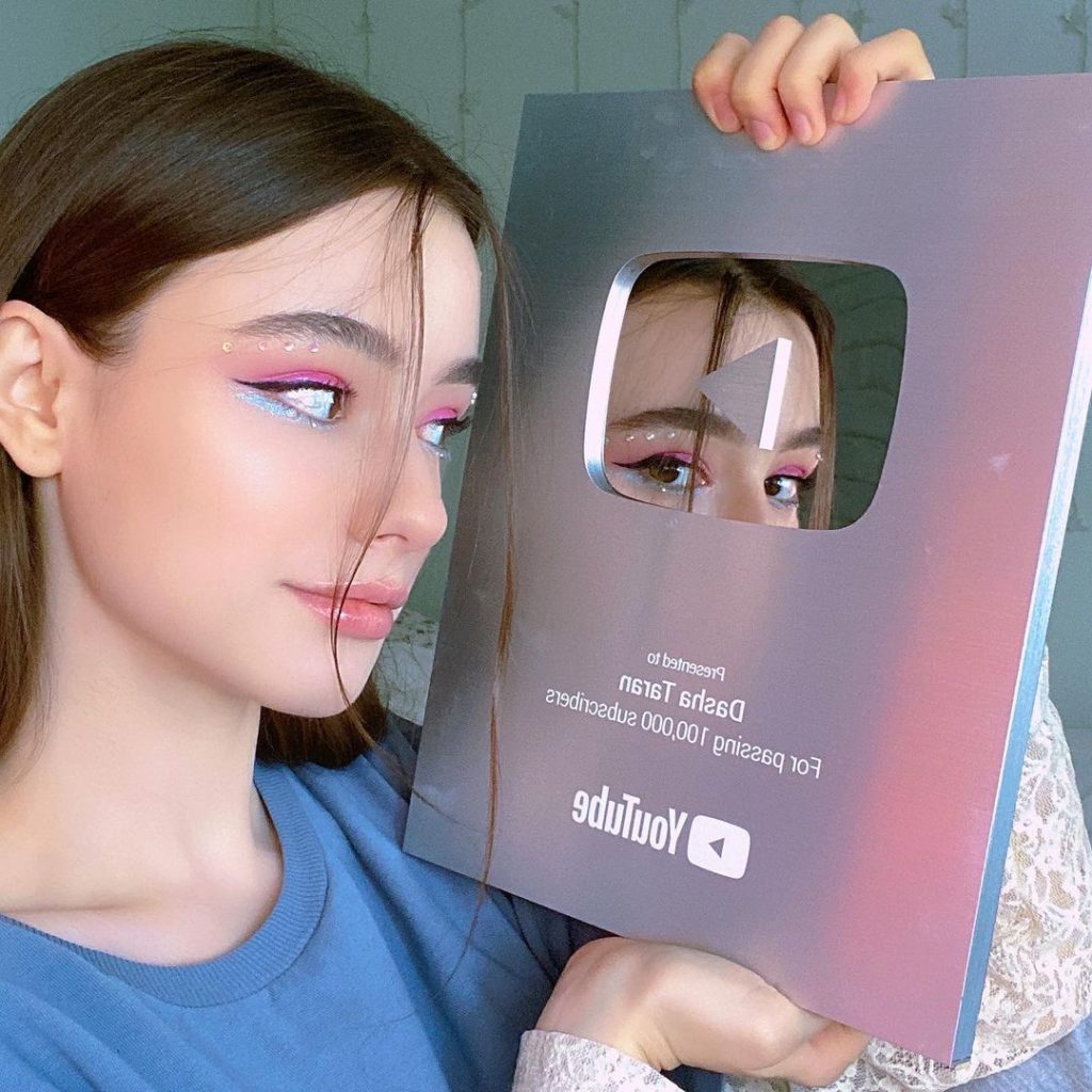 Dasha Taran holding her Youtube Play Button