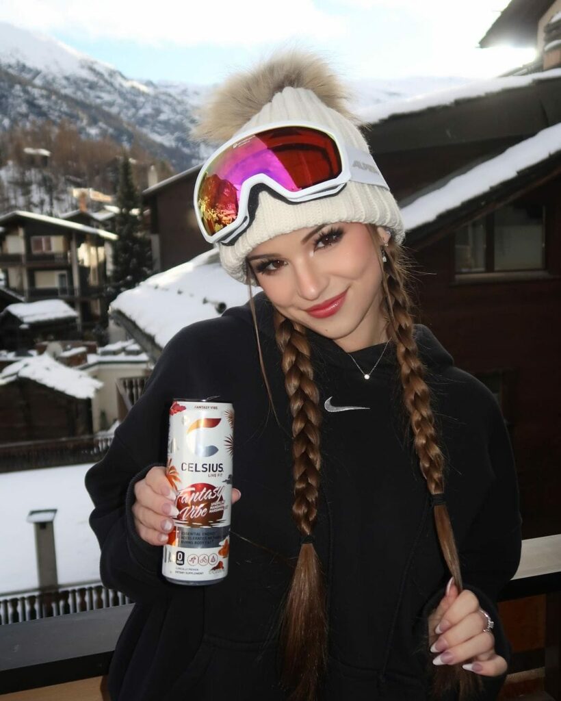 Brooke Monk posing for picture while holding CELSIUS Drink Can in Zermatt, Switzerland.